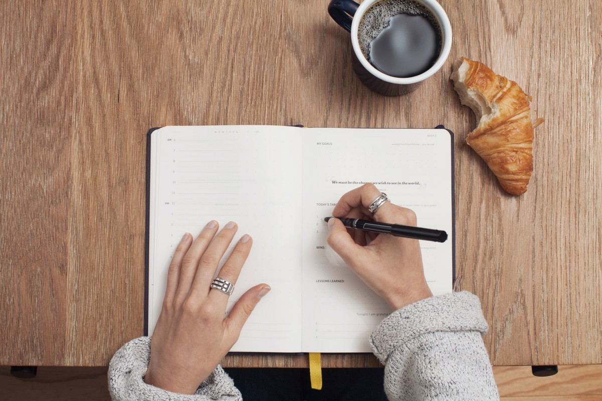 Pisanje u bilježnicu, kroasan i kava
